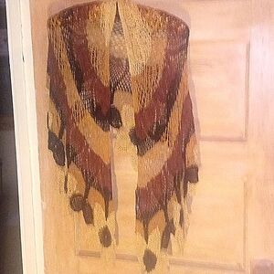 Tricolored shawl with decorative flowers that adorne the bottom.